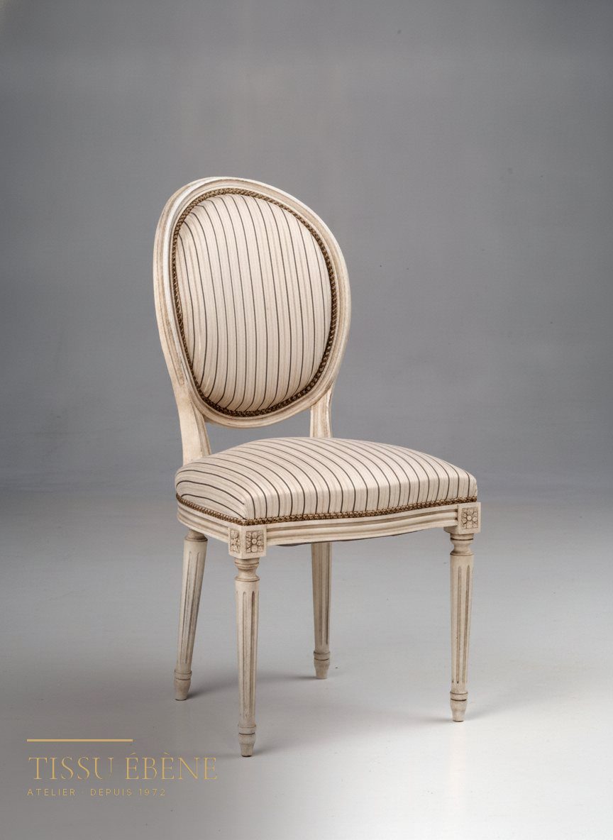 Chaise médaillon laquée ivoire, tissu rayé et galon doré bordant l’assise et le dossier