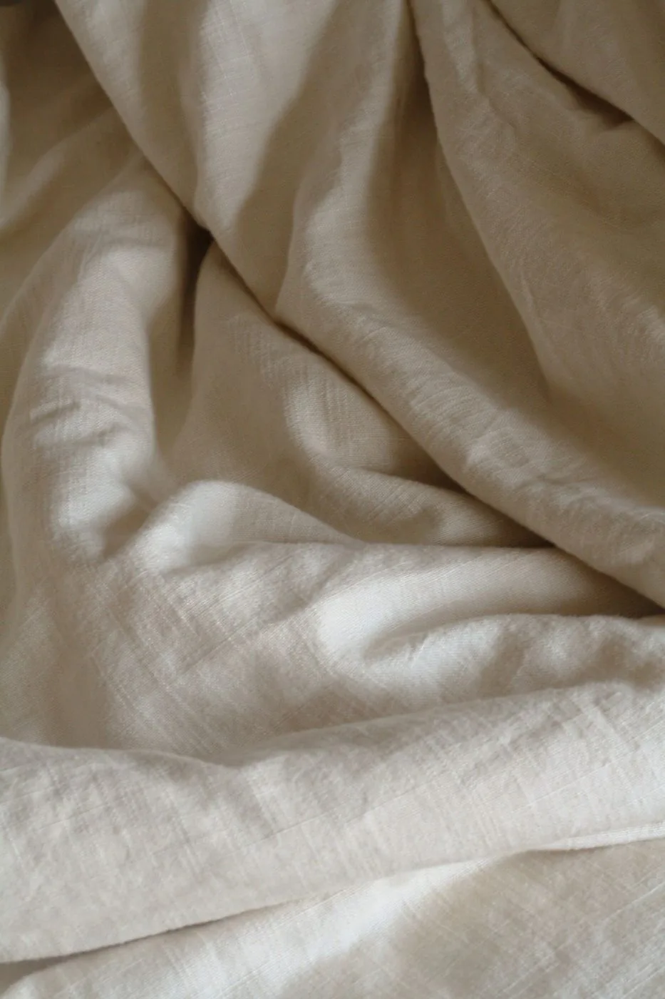 Étoffe de lin écru froissée, gros plan sur le tissage et les plis