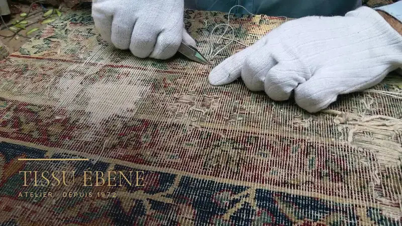 Tapis ancien us&eacute; jusqu&rsquo;&agrave; la trame, pris en charge pour restauration &agrave; l&rsquo;atelier